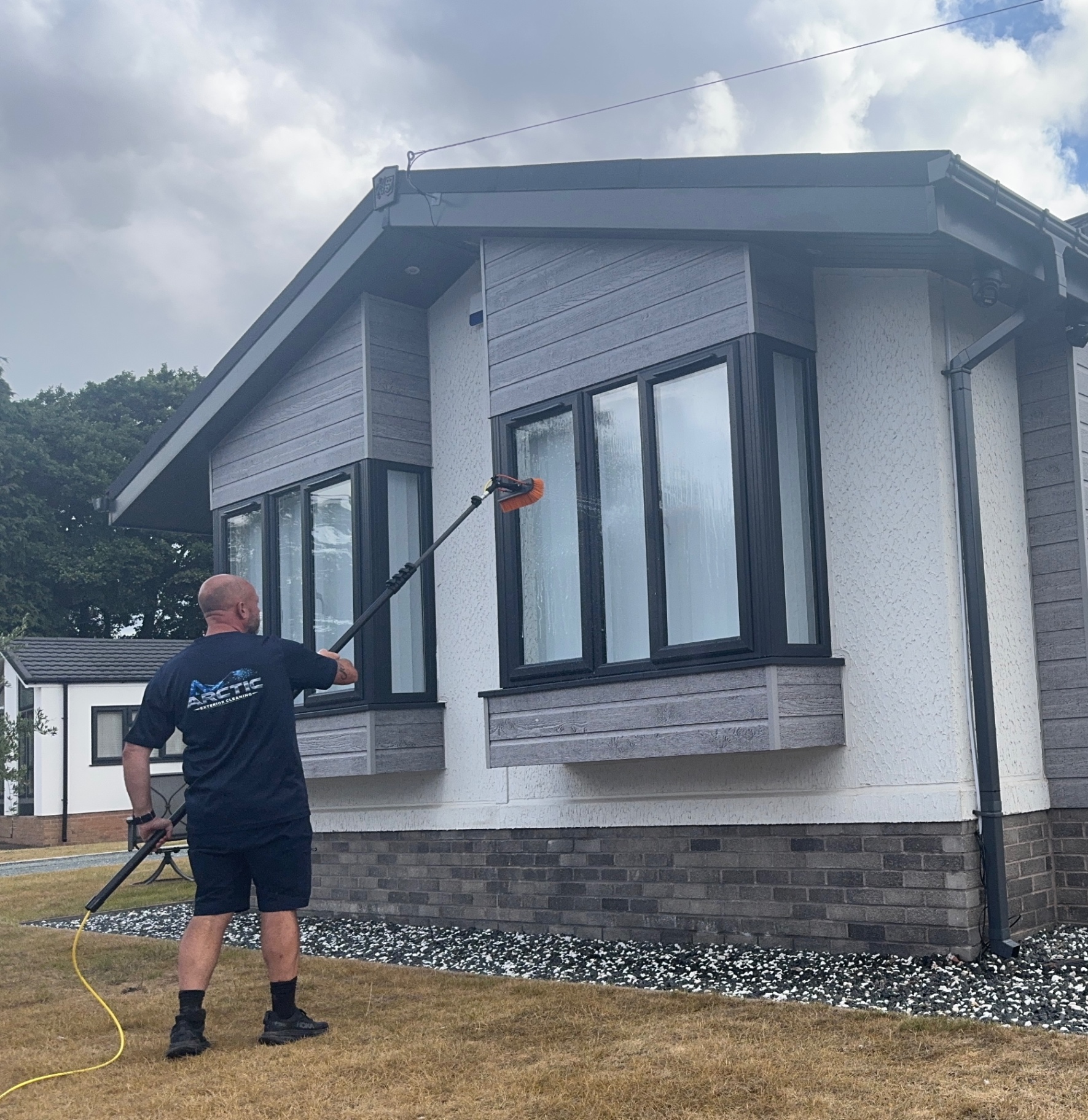 Arctic Exterior Cleaning technician cleaning a domestic property's windows and cladding with a water-fed pole